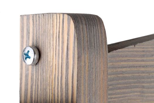 Fragment of a wooden product with a screw on a white background close-up