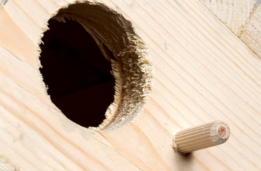 Fragment of a wooden birdhouse on a white background
