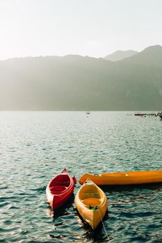 Kayaks moored in the water. Empty kayaks without people. In the Bay of Kotor, in Montenegro.