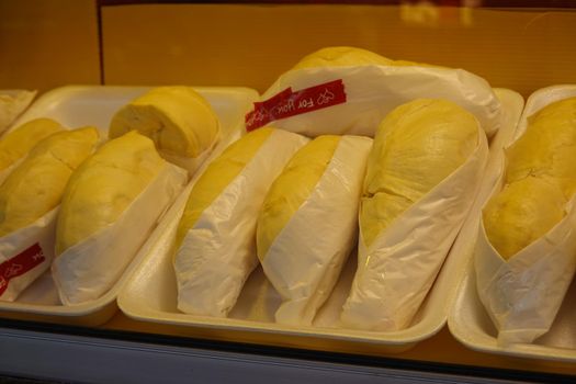 durian fruit in packages on sale in market, yellow durian in packaging as seasonal fruit of Thailand. 