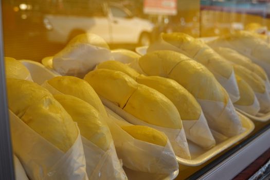 durian fruit in packages on sale in market, yellow durian in packaging as seasonal fruit of Thailand. 