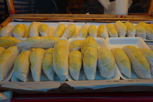 durian fruit in packages on sale in market, yellow durian in packaging as seasonal fruit of Thailand. 