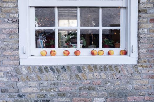 Red and yellow apples lying on a white windowledge of a farm for decoration