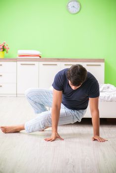 Young man in pajamas doing morning exercises 