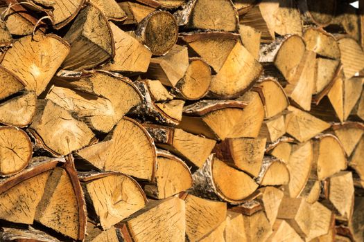 Pile of neatly stacked chopped timber logs for the fireplace