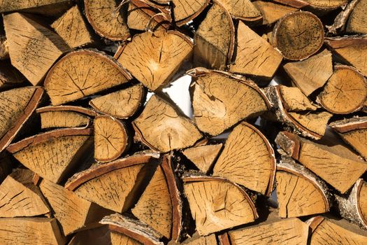 Pile of neatly stacked chopped timber logs for the fireplace