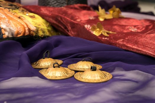 Close-up of zills for bellydancing on a purple veil with arabic cushions