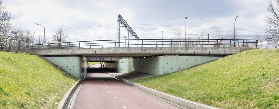 Tunnel under the railroad in Boxtel The Netherlands with catenary wire and signposts