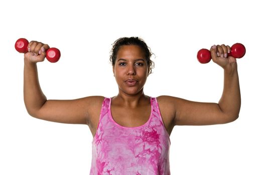 Mixed raced young woman  in pink shirt exercising with red 2 kg weights dumbbells isolated in white