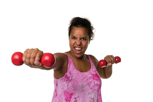 Mixed raced young woman  in pink shirt exercising with red 2 kg weights dumbbells isolated in white