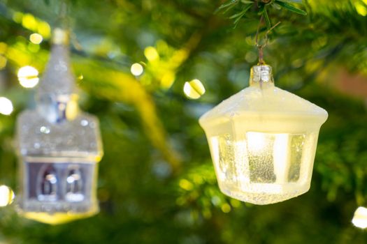 Christmas decoration ornaments  from glass with white and silver hanging in a christmas tree with lights