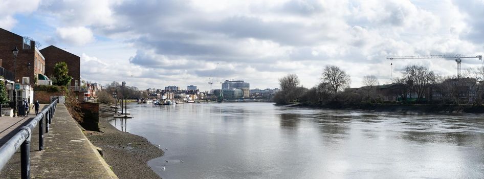 Panoramic view of river Thames toward the City, from Thames path, near Hammersmith. London, England, March 2017. At low tide in spring