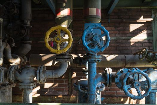 Yellow and blue pipes and valve handle wheel at the abandonned blast furnace at Duisburg Landschafts Park Germany