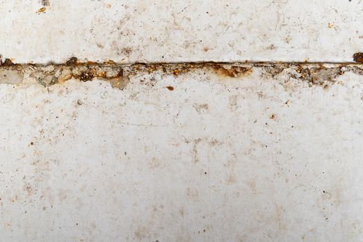 A Full frame background or floor made of concrete with concrete paint and dirt, cracks, filth and leaf white with brown