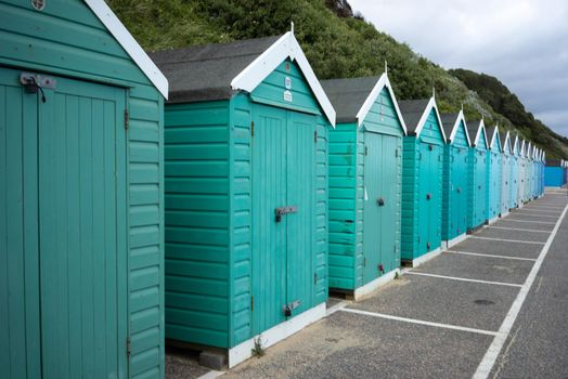 Colorful Beach huts, in green and blue colors, at the  boulevard in Bournemouth, Dorset, UK, England on cloudy day in summer