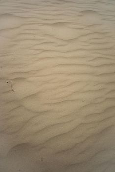 a Close up of a sandy beach with waves and structures seen from above background and full frame with copy space