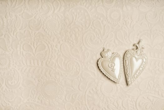 a Full frame background of two white hearts on a seamless detailed lace pattern on white background with copy space