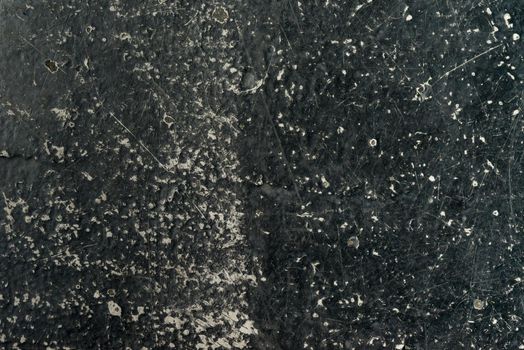 an empty background of black concrete that is worn down or weathered and showing texture with copy space or space for tekst