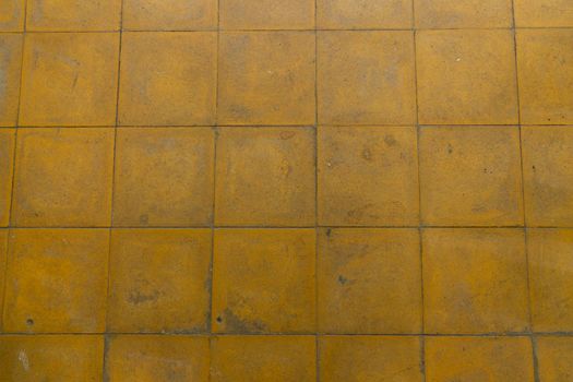 A yellow tiled old and worn down floor