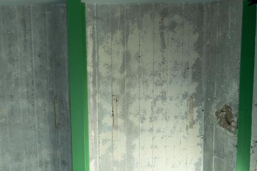 An abstract ceiling of concrete made of plates and green beams