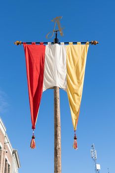 Dutch Flag, in red, white and yellow, of traditional festival named Carnaval, like Mardi Gras, in 's-Hertogenbosch, Oeteldonk with a blue sky