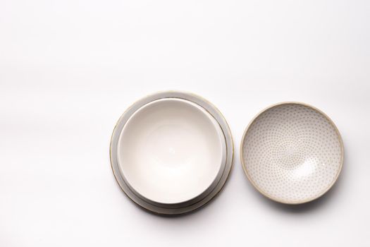 Three empty dishes or cups of blanc earthenware isolated on a white background seen from above or top view