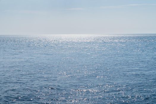 a Blue sea or Atlantic Ocean with small waves, reflection of the sun and clear blue sky in the summer space for tekst