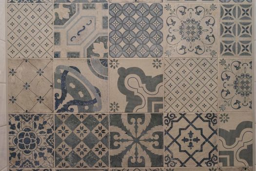 Decorative blue and cream tiles with different patterns on wall