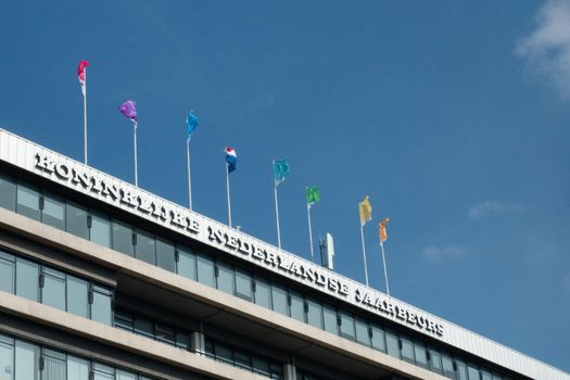 UTRECHT / NETHERLANDS - APRIL 15, 2019: Facade with flags and a blue sky Dutch conference centre Jaarbeurs