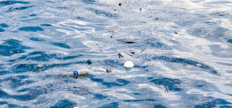 plastic bottled water floating on a beach side and other flowing plastic garbage