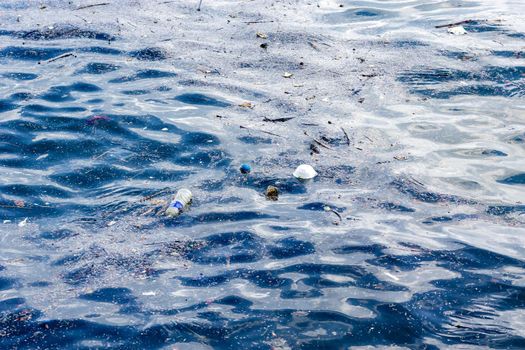 plastic bottled water floating on a beach side and other flowing plastic garbage
