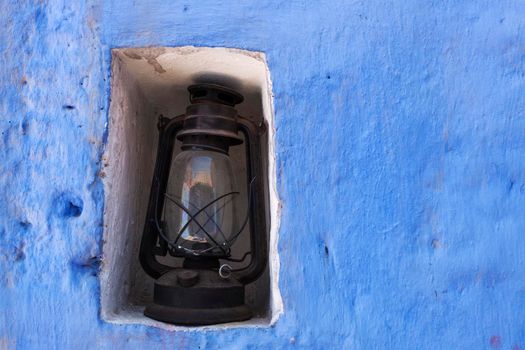 Old lamp and the blue wall. Seen in Arequipa, Peru.
