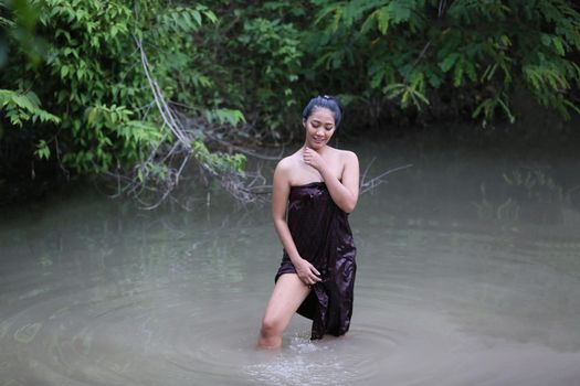 Rural Young Asian Women Bathing In A River, or Portrait Of Beautiful Young Asian Woman Bathing In The River. Asian sexy woman bathing in creek. 