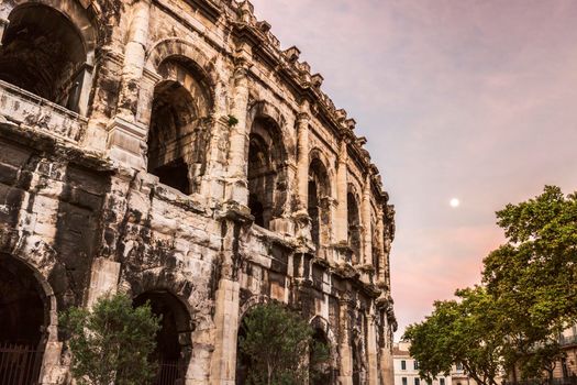 Arena of Nimes at sunrise and moonset. Nimes, Occitanie, France.