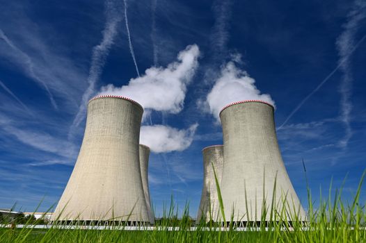 Dukovany Nuclear Power Plant - Czech Republic.
Large chimneys with blue sky and smoke. Concept for industry and environment.