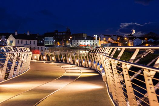 Peace Bridge in Derry and full moon. Derry, Northern Ireland, United Kingdom.