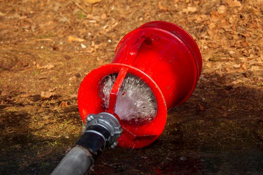 Fire hose with water on the ground. Fire extinguishing