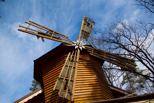 Wooden mill on a background of blue sky.