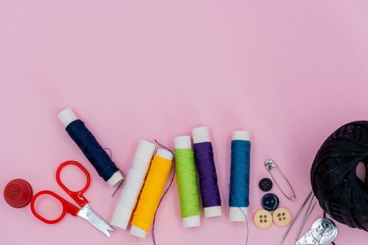 Sewing background. Accessories for needlework on wooden background. Spools of thread, scissors, buttons, measuring tape, sewing supplies. Set for needlework top view