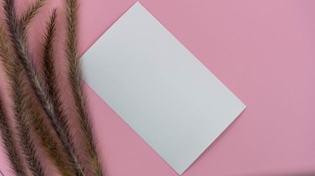 Top view of blank paper page on pink background office desk and different objects. Minimal flat lay style