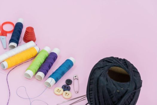 Sewing background. Accessories for needlework on wooden background. Spools of thread, scissors, buttons, measuring tape, sewing supplies. Set for needlework top view