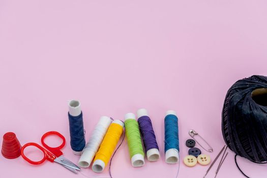 Sewing kit accessories.set tools for tailoring and colorful threads,needles,pins,scissors on green background mockup frame top view.