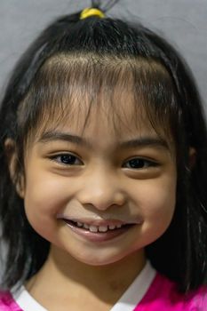 Close-up portrait of gorgeous little girl with milk mustache drinking a glass of milk at home, food and drink concept, healthy food, indoor