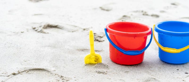 Children's beach toys - buckets, spade and shovel on sand on a sunny day