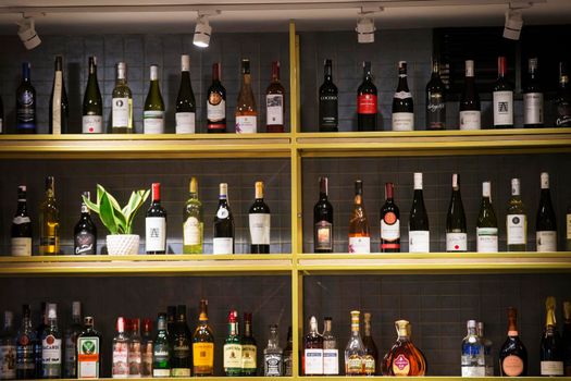 Belarus, the city of Gomil, February 08, 2020. Showcase wine shop. Many bottles of wine stand on a shelf.