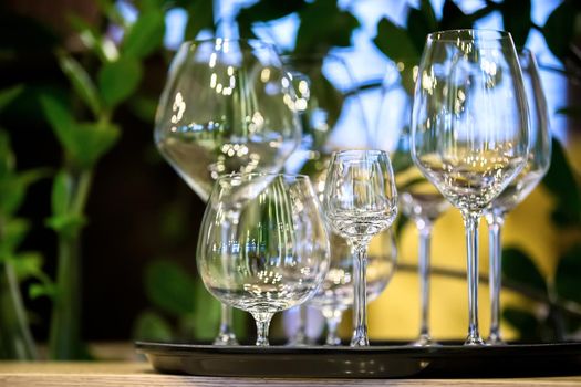 Beautiful empty glass goblets of different sizes. A tray with glasses from a restaurant.
