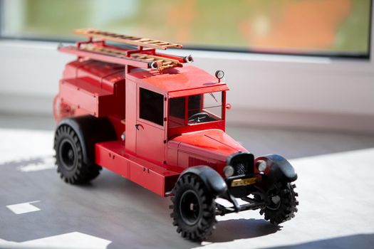 Toy retro fire truck of red color.