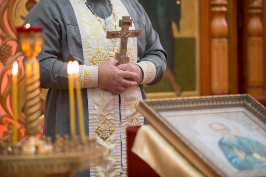 Priest with a cross on the background of the icon.