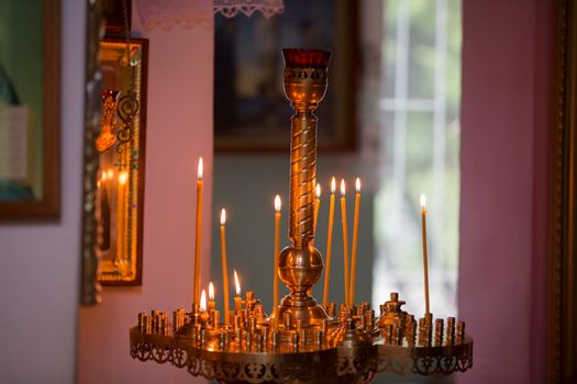 Church candles in a gold candlestick in the temple.