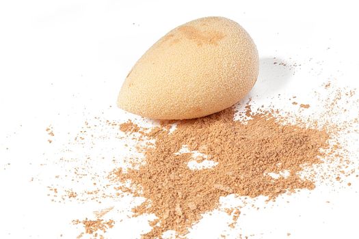 Cosmetic sponge with powder isolated on a white background. Loose makeup base.